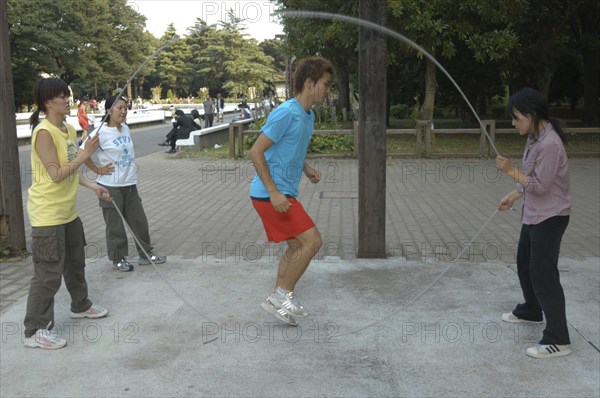 JAPAN, Honshu, Tokyo, "Harajuku. Yoyogi Park. 24 year old student Kusan Osaki, jumps rope with friends on Saturday afternoon"