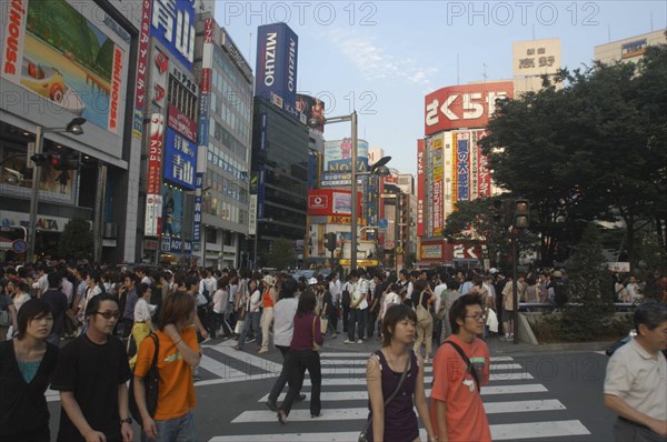 JAPAN, Honshu, Tokyo, Crowds on pedestrian crossing on Shinjuku-dori avenue on Saturday evening directly in front of Shinjuku station
