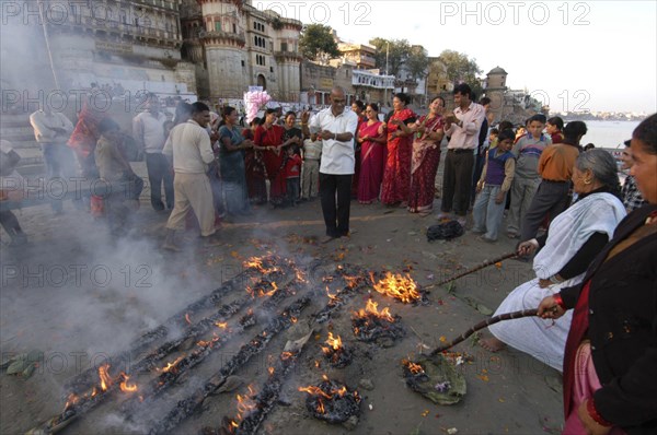 INDIA, Uttar Pradesh, Varanasi , Nepali man dances at a Hindu ceremony at Asi Ghat beside the Ganges River