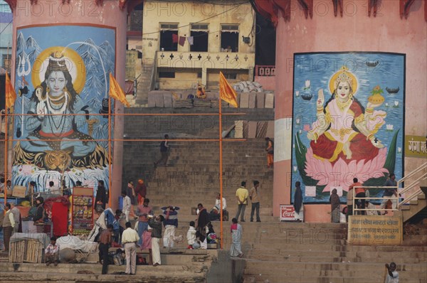 INDIA, Uttar Pradesh, Varanasi , Murals of Shiva and Parbati at Dashaswamedh Ghat with Hindu pilgrims on the steps