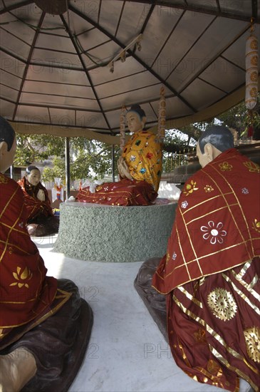 INDIA, Uttar Pradesh, Sarnath, Statues of the Buddha preaching his first sermon in front of the Bodhi tree next to Mulgandha Kuti Vihara.