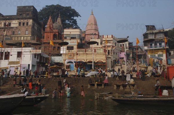 INDIA, Uttar Pradesh, Varanasi, Dashaswamedh Ghat with early morning pilgrims bathing in the Ganges River