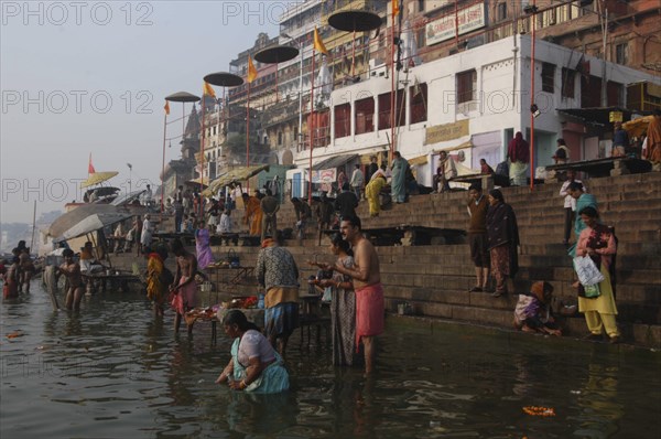 INDIA, Uttar Pradesh, Varanasi, Dashaswamedh Ghat with early morning bathers in the Ganges River