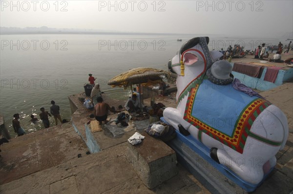 INDIA, Uttar Pradesh, Varanasi, Figure of Shivas bull Nandi overlooking the steps of Ghai Ghat by the Ganges River