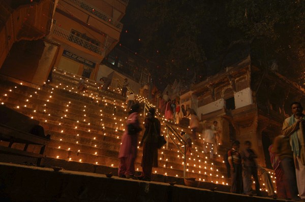 INDIA, Uttar Pradesh, Varanasi, Deep Diwali Festival. View looking up steps leading down to the Ganges River with festival goers and oil lamps