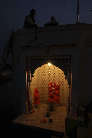 INDIA, Uttar Pradesh, Varanasi, Near Hanuman Ghat. A Hanuman Shrine on the Ganges River at night