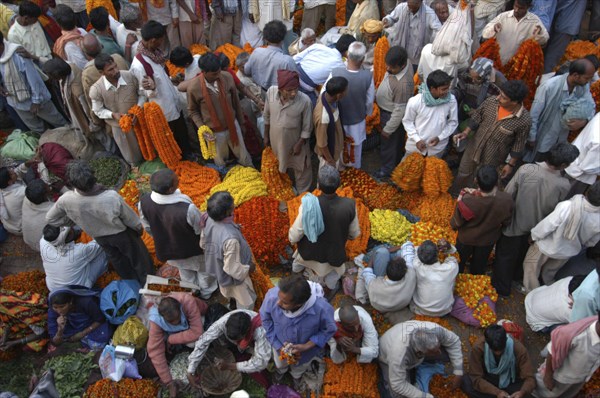 INDIA, Uttar Pradesh, Varanasi, View looking down on busy flower market with a majority of male vendors selling mostly marigolds