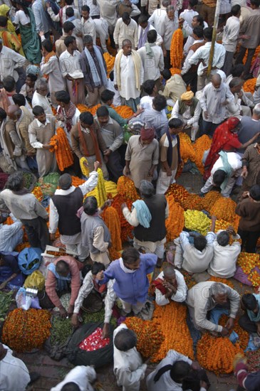 INDIA, Uttar Pradesh, Varanasi, View looking down on busy flower market with a majority of male vendors selling mostly marigolds