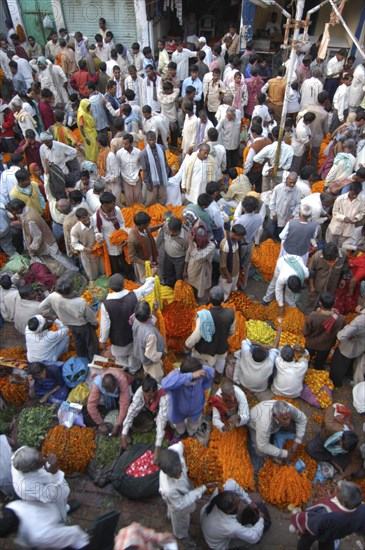 INDIA, Uttar Pradesh, Varanasi, View looking down on busy flower market with a majority of male vendors selling mostly marigolds