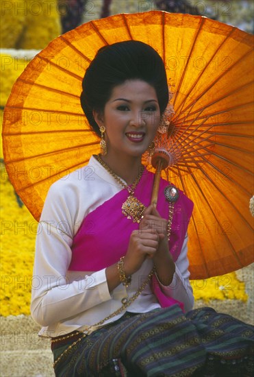 THAILAND, Chiang Mai, Portrait of young woman riding the beauty contest float in the Flower Festival parade