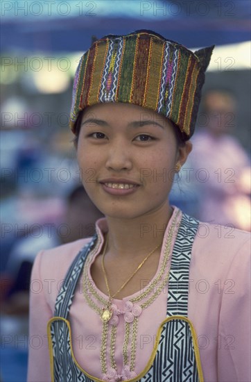 THAILAND, Chiang Mai, Wat Pa Pao. Portrait of a young Shan woman in traditional Shan attire at a food shop during Poi Sang Long