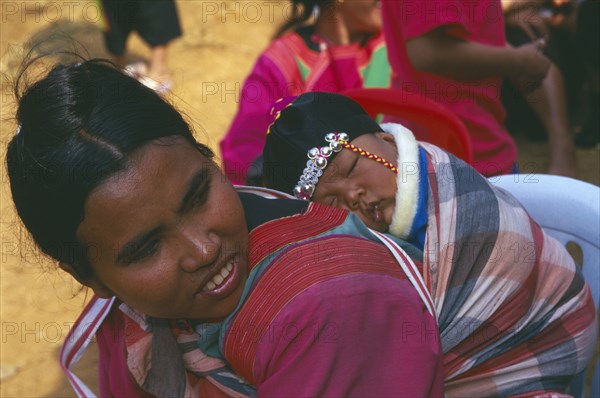 THAILAND, Chiang Rai, Doi Lan, Lisu woman with her infant son carried papoose style on her back