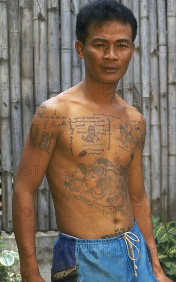 THAILAND, Chiang Mai, Portrait of a man with tatooed torso and arms