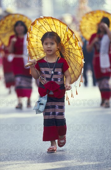THAILAND, Chiang Mai, Young girl in Flower festival parade dressed in traditional attire with a paper parasol
