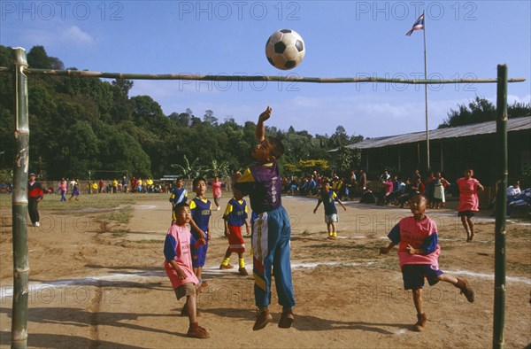 THAILAND, Chiang Rai Province, Doi Lan, Lisu boys playing soccer in a village school yard