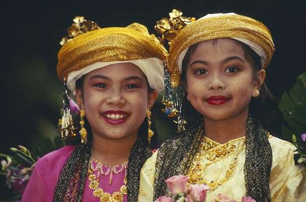 THAILAND, Chiang Mai, Two young Thai girls in traditional northern Thai attire for the Flower Festival parade