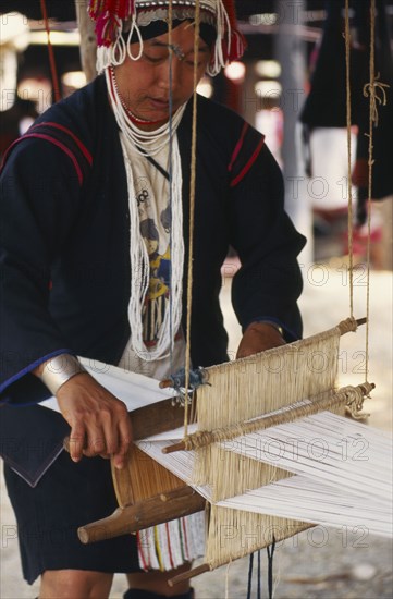 THAILAND, Chiang Mai Province, Akha woman weaving cloth on an Akha loom