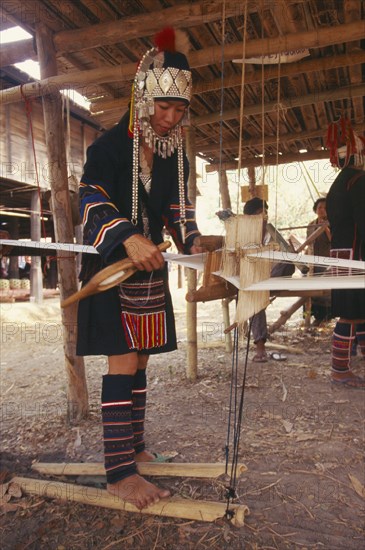 THAILAND, Chiang Mai Province, Akha woman weaving cloth on an Akha loom