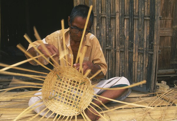 THAILAND, Chiang Mai Province, Red Lahu man weaving a bamboo basket