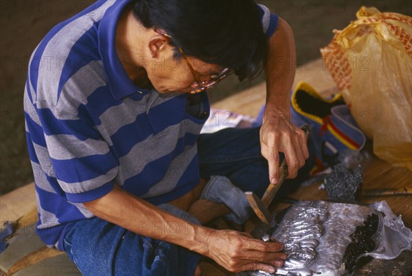 THAILAND, Chiang Mai, Wat Sri Suphan, Silversmith making repousse picture of elephants