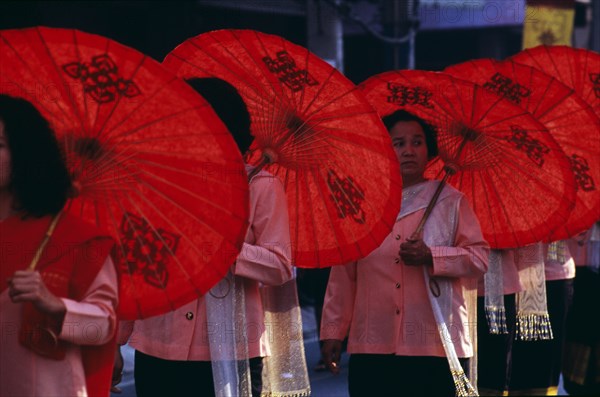 THAILAND, Chiang Mai, Women carrying Sah paper umbrellas marching in the Flower Festival Parade