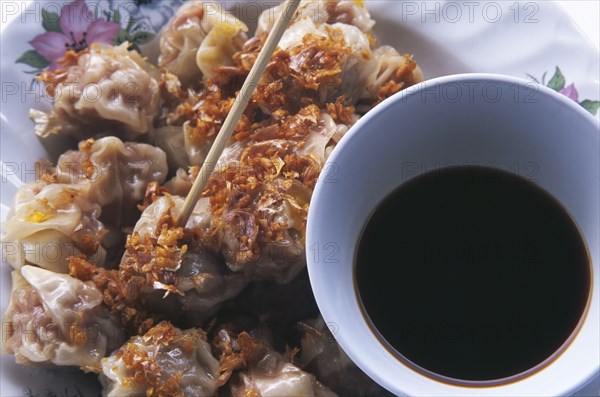 THAILAND, General, Thai style steamed pork filled dumplings called Khanom jiip with a bowl of Chinese sweet vinegar