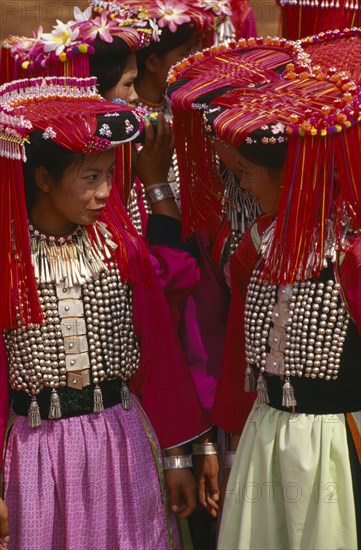 THAILAND, Chiang Rai Province, Huai Khrai, Lisu women dressed in their New Year finery turned towards each other in conversation.
