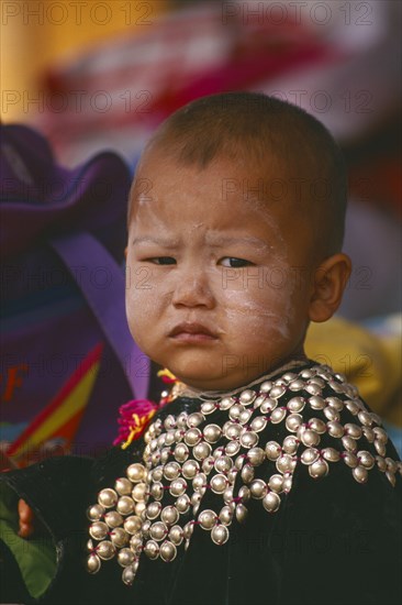 THAILAND, Chiang Rai Province, Huai Khrai, Portrait of a Lisu infant boy wearing New Year silver studded jacket