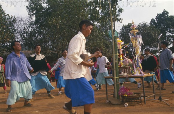THAILAND, Chiang Rai Province, Huai Khrai, Lisu people dancing around New Year tree to a banjo player