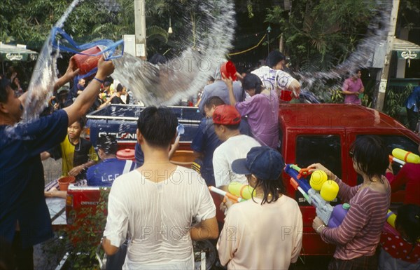 THAILAND, Chiang Mai, Songkran aka Thai New Year. Revellers in a pickup truck attempting to catch some of the water thrown at them