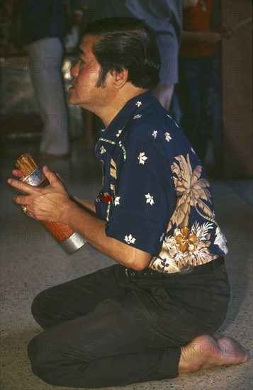 THAILAND, Chiang Mai, Chinese New Year. Worshipper at a Chinese temple during the New Year