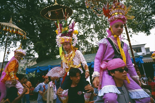THAILAND, Chiang Mai, Shan Poi San Long. Crystal Children ceremony with Luk Kaeo in costume being carried on mens shoulders at Wat Pa Pao