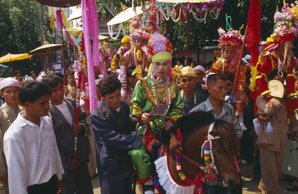 THAILAND, Chiang Mai, Shan Poi San Long. Crystal Children ceremony with Luk Kaeo in costume riding a pony in parade to Wat Pa Pao