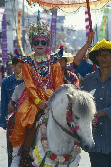 THAILAND, Chiang Mai, Shan Poi San Long. Crystal Children ceremony with child in costume riding a pony in the parade prior to novice monk ordination
