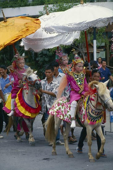 THAILAND, Chiang Mai, Crystal Children. Hill tribe boys ordination parade. Shan novice candidates riding ponies