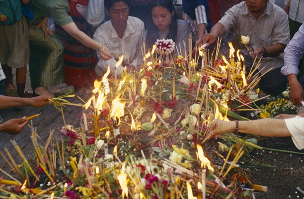 THAILAND, Chiang Mai, Wat Jedi Luang, Inthakhin Ceremony. People with offerings of flowers candles and joss sticks