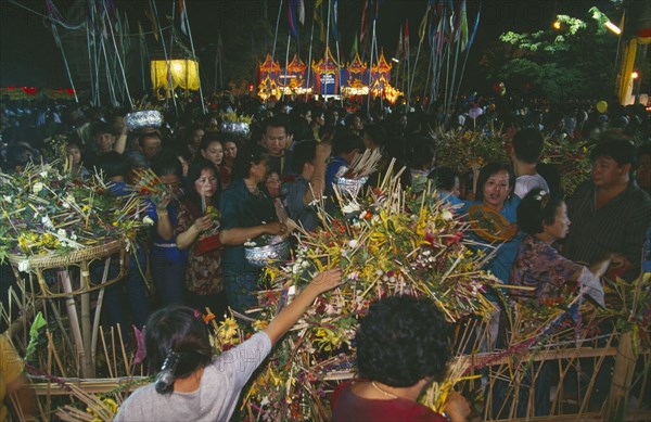 THAILAND, Chiang Mai, Wat Jedi Luang, Inthakhin Ceremony. People with offerings of flowers and joss sticks circimambulating