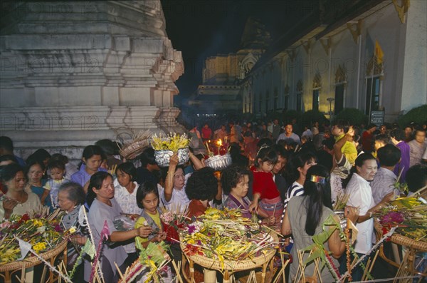 THAILAND, Chiang Mai, Wat Jedi Luang, Inthakhin Ceremony. People with offerings of flowers and joss sticks circimambulating