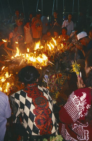 THAILAND, Chiang Mai, Wat Jedi Luang, Inthakhin Ceremony. People offering candles and joss sticks