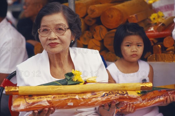 THAILAND, Chiang Mai, Wat Maw Kham Tuang, "Revered monks funeral with worshippers holding sandalwood, monks robes and flower offerings"