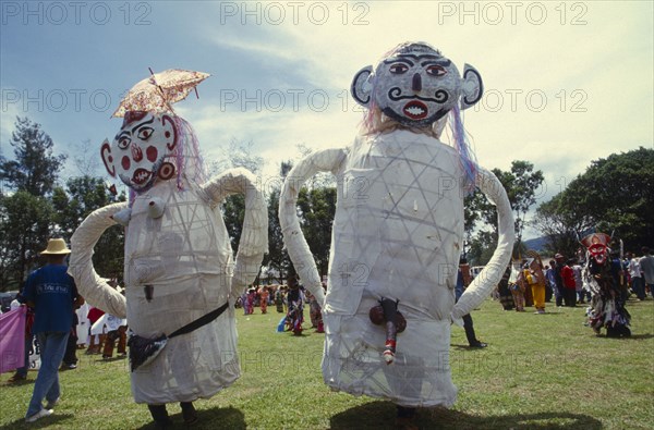 THAILAND, Loei Province, Dan Sai, Phi Ta Khon or Spirit Festival. People wearing a pair of male and female big spirits costumes