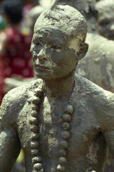 THAILAND, Loei Province, Dan Sai, Phi Ta Khon or Spirit Festival. Mud man covered in a thick layer of mud