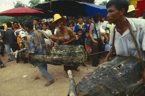 THAILAND, Loei Province, Dan Sai, Phi Ta Khon or Spirit Festival. Two men in water buffalo costumes and one man dressed as a woman