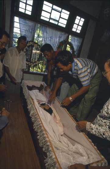 MYANMAR, Kachin State, Myitkyina, Jinghpaw funeral with the deceased in a coffin at the families home