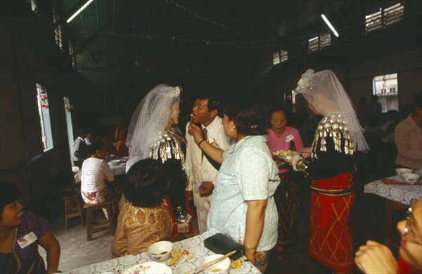 MYANMAR, Kachin State, Myitkyina, Jinghpaw wedding reception with Bridal couple and guests at the YMCA hall