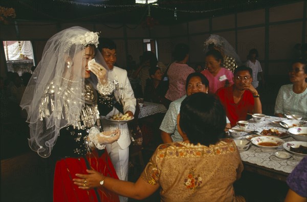 MYANMAR, Kachin State, Myitkyina, Jinghpaw wedding reception with Bridal couple and guests at the YMCA hall