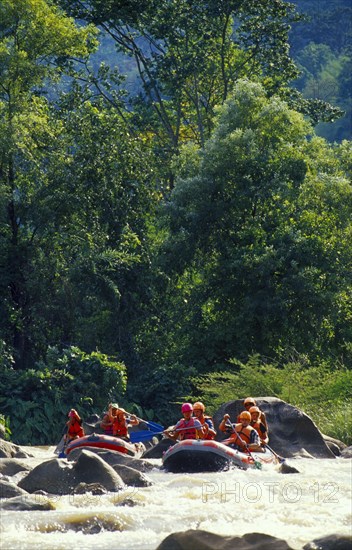 THAILAND, Chiang Mai Province, Western tourists and Thai guides white water river rafting on the Mae Taeng River