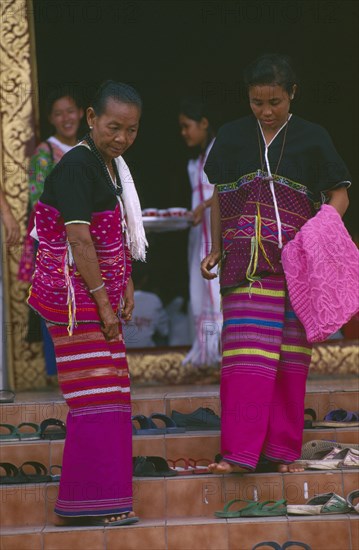 THAILAND, Chiang Mai, Wat Phra Singh, Two Karen women finding their shoes on steps upon leaving a ceremony