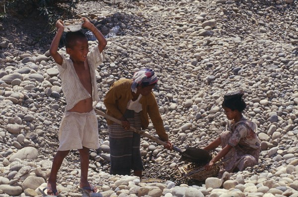 MYANMAR, Kachin State, Myitkyina, People gathering stones for road building on the upper Ayeyarwady River