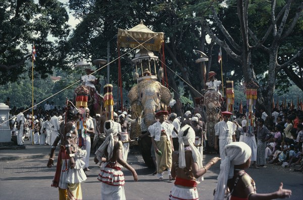 SRI LANKA, Kandy, "Esala Perahera festival parade with decorated Maligawa Tusker elephant carrying replica of the golden relic casket, dancers and musicians."